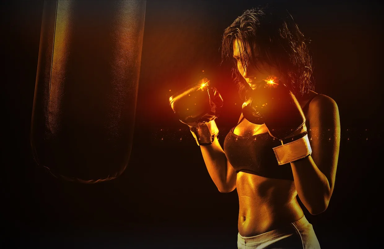 Boxeadora golpeando el saco en un gimnasio con luz cálida