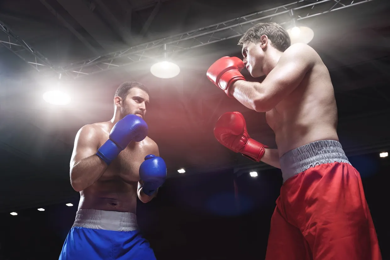 Dos boxeadores intercambiando golpes en el ring durante un combate