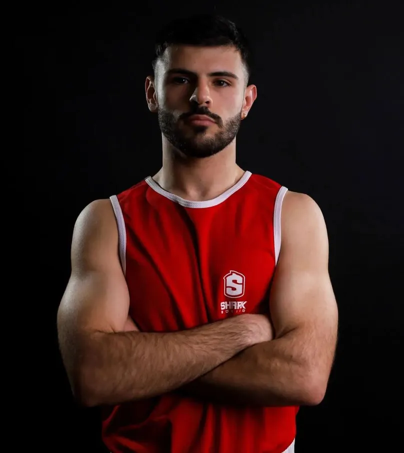 Boxeador con camiseta de tirantes roja y los brazos cruzados